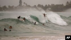 Surfistas enfrentan grandes olas generadas por el huracán Douglas en Laie Beach Park, en Laie, Hawái, el domingo, 26 de julio de 2020.