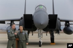 Lt. Gen. Terrence O'Shaughnessy, left, 7th Air Force commander of the U.S. Forces to Korea, and South Korean Air Forces Commander Lee Wang-geun pose in front of a South Korean F-15K fighter jet after a press briefing on the flight by a U.S. Air Force B-52