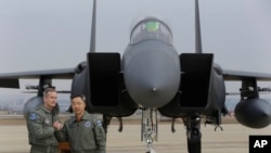 Lt. Gen. Terrence O'Shaughnessy, left, 7th Air Force commander of the U.S. Forces to Korea, and South Korean Air Forces Commander Lee Wang-geun pose in front of a South Korean F-15K fighter jet after a press briefing on the flight by a U.S. Air Force B-52