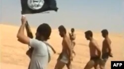 An image grab taken from a video uploaded on social networks, shows young men in underwear being marched barefoot along a desert road before being allegedly executed on Aug. 27, 2014 by Islamic State (IS) militants at an undisclosed location in Syria's Raqa Province.