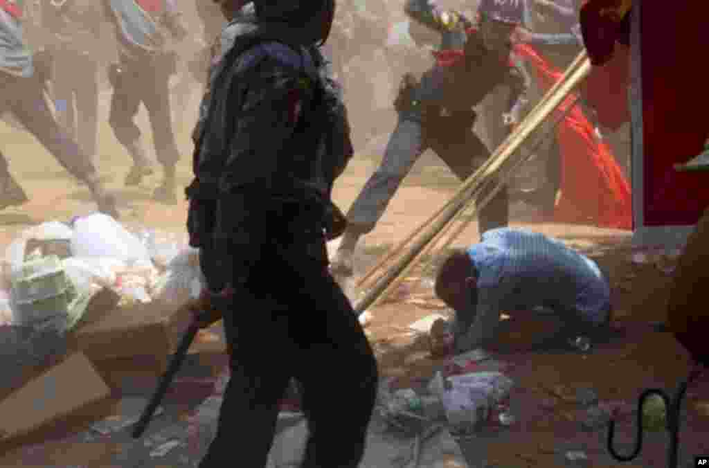 یک مامور پلیس در حال کتک زدن دانشجوی معترض در لتپادان (میانمار) ديده می&zwnj;شود.