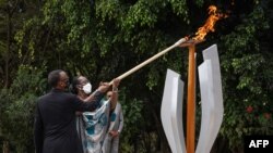 Le président rwandais Paul Kagame et la première dame Jeannette Kagame allument une flamme commémorative pour la 27e commémoration du génocide de 1994 contre les Tutsi au Mémorial du génocide de Kigali, au Rwanda, le 7 avril 2021.