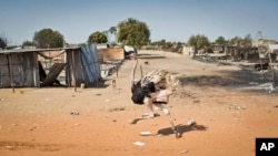An ostrich runs through empty streets and past destroyed buildings, after government forces on Friday retook from rebel forces the provincial capital of Bentiu, in Unity State, South Sudan, Jan. 12, 2014.