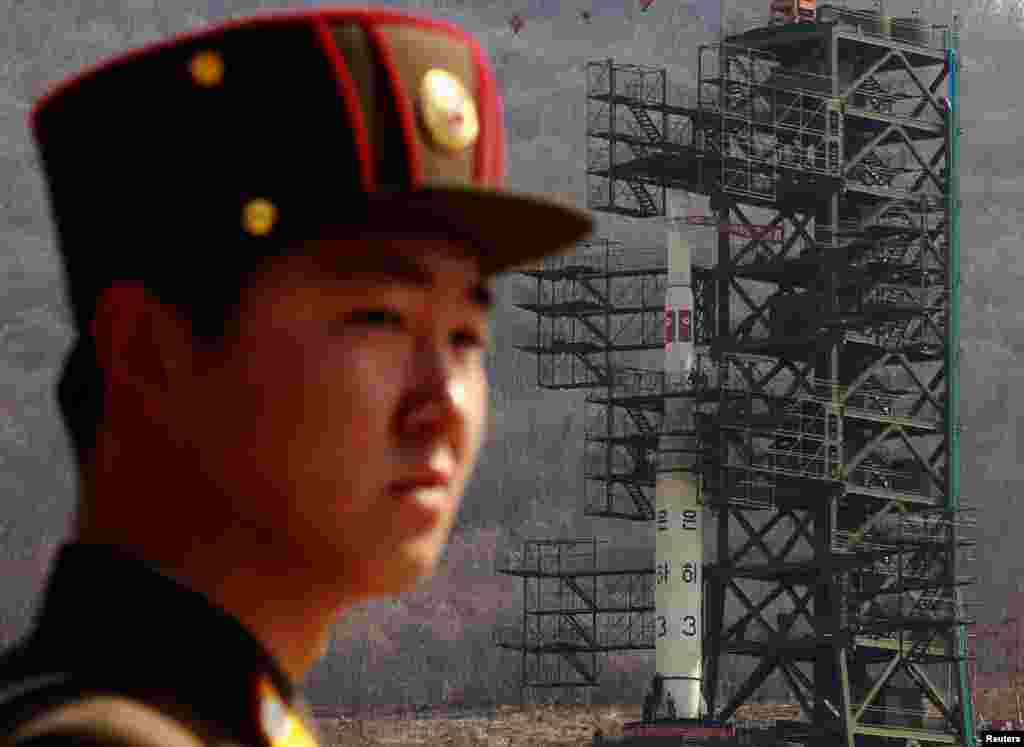 April 8: A soldier stands guard in front of the Unha-3 rocket sitting on a launch pad at the West Sea Satellite Launch Site, northwest of Pyongyang, North Korea. 