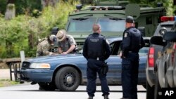 Law enforcement officers gather at an area of a possible sighting of two escaped prisoners from Clinton Correctional Facility in Dannemora, on June 23, 2015, in Mountain View, N.Y. 