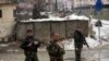 National army soldiers stand guard at the site of suicide attack near the military academy in Kabul, Afghanistan, Tuesday, Feb. 11, 2020.