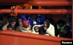 Migrants wait to disembark from a tug boat in the Sicilian harbour of Pozzallo, southern Italy, May 4, 2015. REUTERS/Antonio Parrinello