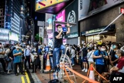 黄之锋在香港铜锣湾街头讲话，当时附近的维多利亚公园正在举行当局以新冠疫情为由禁止的纪念六四烛光集会。（2020年6月4日）