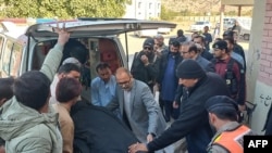 People move the dead body of a police personnel killed in an attack by militants while guarding polio vaccinators, in Karak of Khyber Pakhtunkhwa province on Dec. 16, 2024. 