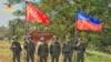 FILE - A photo released by the Arakan Army shows its members posing in front of the Gwa town signboard at the entrance gate, following their capture of Gwa Township in southern Rakhine State, Myanmar, on Dec. 29, 2024.