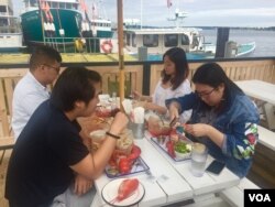 Chinese tourists feast on lobster in Maine. (J.Taboh/VOA)