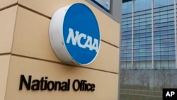 FILE - Signage at the headquarters of the NCAA is viewed in Indianapolis, March 12, 2020. A U.S. appeals court in Philadelphia has ruled that some college athletes may qualify as employees under federal wage-and-hour laws.