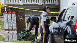 Police continue to search for evidence after a shooting in a residential neighborhood of the eastern city of Moncton, New Brunswick, June 5, 2014.