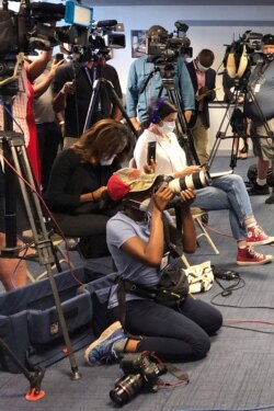 Atlanta Journal-Constitution staff photojournalist Alyssa Pointer, kneeling, works during a news conference, June 2, 2020, in Atlanta. Pointer was detained by Georgia Department of Natural Resources officers during a protest downtown.