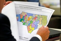 FILE - A lawmaker studies a district map during a joint select committee meeting on redistricting in Raleigh, N.C., July 26, 2017.