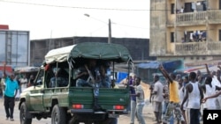 Supporters of opposition leader Alassane Ouattara gesture to passing soldiers, Abidjan, Ivory Coast, Dec. 2, 2010.