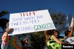 People holding placards take part in a protest in support of gun control in Coral Springs, Fla., Feb. 17, 2018.