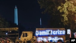 Demonstrators project the words "Demilitarize the police" onto a military vehicle as protests continue over the death of George Floyd, June 3, 2020, near the White House in Washington. 