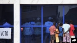 Boys watch electoral officials count votes through a window in Guinea's capital Bissau, March 18, 2012. 