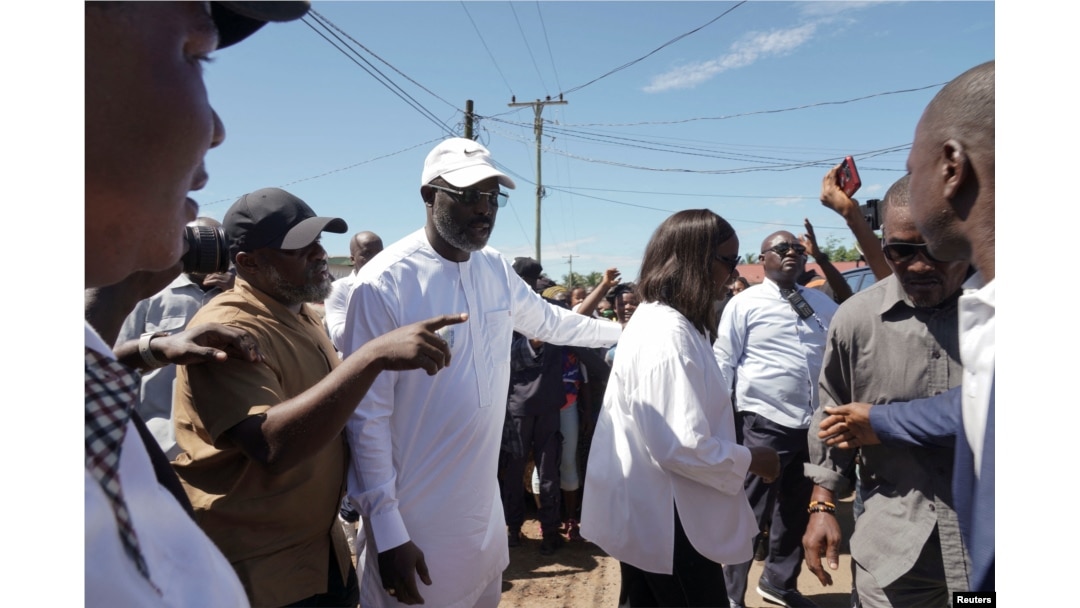 The leader of Liberia's ruling party Coalition for Democratic Change, President George Weah, walks with his wife, Clar Weah, after casting his vote during the presidential elections in Monrovia, Liberia, on Oct. 10, 2023.