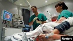 FILE - A doctor performs a colonoscopy on a patient at the Ambroise Pare hospital in Marseille, southern France.