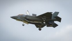 FILE - The F-35 Lightning II hovers in front of crowds during its first solo appearance at the Farnborough Air Show in the United Kingdom, July 12, 2016.