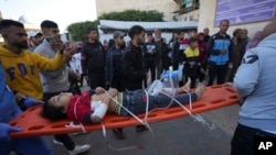 A wounded Palestinian child is carried on a stretcher at the Al-Aqsa Martyrs hospital in Deir al-Balah, following an Israeli bombardment in Nuseirat, central Gaza, Dec. 4, 2024.