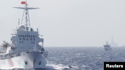 Tàu Cảnh sát biển Trung Quốc gần giàn khoan Hải Dương 981 ở Biển Ðông, khoảng 210 km (130 dặm) ngoài khơi bờ biển Việt Nam, ngày 14/5/2014. Trung Quốc cung cấp cho giàn khoan đầu một đoàn hộ tống gồm 80 tàu dân sự và tuần duyên đến địa điểm nằm trong vùng đặc quyền kinh tế của Việt Nam.