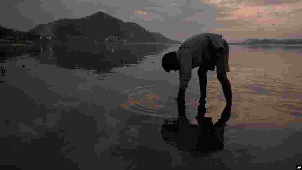 Un garçon cherche des pièces dans la rivière de Brahmaputra à la veille de la Journée mondiale de l&#39;eau à Gauhati, en Inde, le 21 mars 2017.