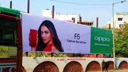 印度乌代普尔，一条神牛经过OPPO新款手机广告。（美国之音朱诺拍摄，2017年11月09日）