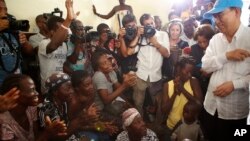 Umunyamabanga Mukuru wa ONU, Ban Ki-moon (mu kuboko kw'iburyo), muri Haiti, aho yagiye kugarukira ku mbarabare zasinzikajwe n'igihuhusi Matthew.