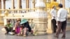 Cambodian street vendors sell lotus flowers and incense sticks on the main sidewalk in front of the Royal Palace in Phnom Penh, Cambodia, April 8, 2020. (Malis Tum/VOA Khmer) 