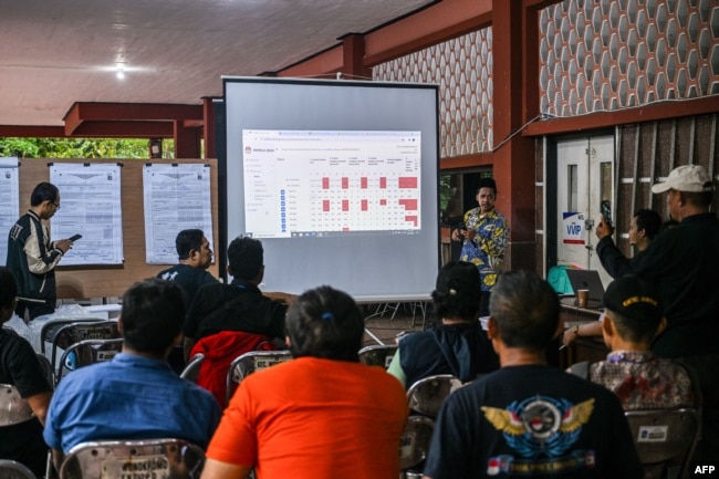Pejabat Komisi Pemilihan Umum (KPU) melakukan rekapitulasi nasional hasil pemilu tingkat kecamatan di Surabaya pada 18 Februari 2024. (Foto: AFP)