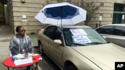 Tyra Moreland, with the Georgia Department of Elections, directs voters away from their usual polling place at an Atlanta library to a new one about two miles away, Nov. 6, 2018. 