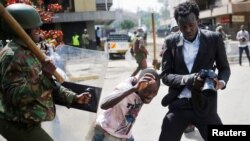 A Kenyan policeman beats a protester during clashes in Nairobi, May 16, 2016.