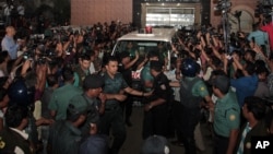 Bangladeshi security personnel cordon an ambulance leaving Central Jail carrying the body of Mohammad Qamaruzzaman, an assistant secretary general of Jamaat-e-Islami party, after he was executed in Dhaka, April 11, 2015. 