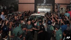 Petugas keamanan Bangladesh mengawal mobil ambulans yang meninggalkan penjara pusat membawa mayat Mohammad Qamaruzzaman, asisten sekertaris jenderal partai Jamaat-e-Islami, setelah pelaksanaan hukuman mati di Dhaka, Bangladesh, 11 April 2015. 