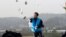 FILE - An activist hurls anti-North Korea leaflets, usually carried across the border by baloons, as police block his planned rally on a road near the demilitarized zone in Paju, South Korea, Oct. 22, 2012.