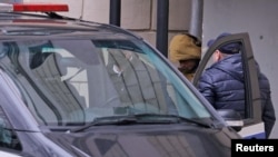 Репортера The Wall Street Journal в России Эвана Гершковича ведут в автомобиль после судебного заседания