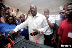 FILE - George Weah, former soccer player and presidential candidate of the Congress for Democratic Change, votes at a polling station in Monrovia, Liberia, Oct.10, 2017.