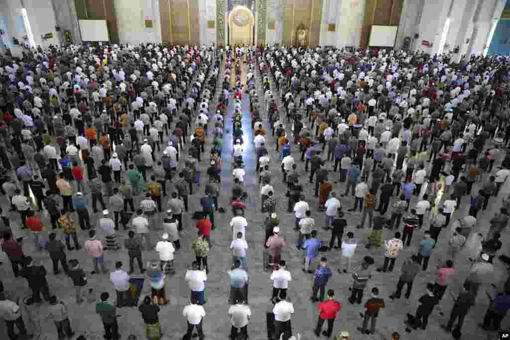 Muslim men perform Friday prayer at a distance of about one meter to each other as part of a social distancing effort to prevent the spread of new coronavirus outbreak, at Al Akbar mosque in Surabaya, East Java, Indonesia.