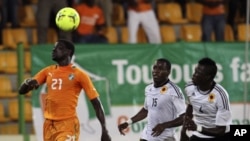 Emmanuel Eboue, da Costa do Marfim, perseguido por Miguel Geraldo Quiami e Dani Massunguna, durante o jogo que ditou a saída das Palancas Negras do CAN 2012