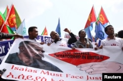 Eritrean refugees chant slogans as they hold a banner with the picture of President Isaias Afwerki during a demonstration in support of a U.N. human rights report accusing Eritrean leaders of crimes against humanity, in Ethiopia's capital, Addis Ababa, Ju