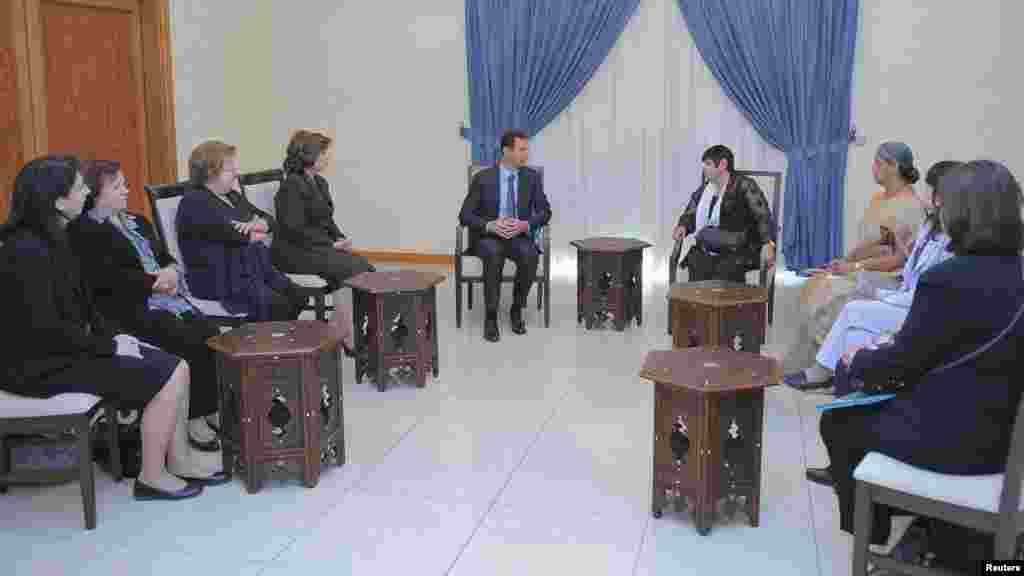 Syria's President Bashar al-Assad meets with a Women's International Democratic Federation delegation, headed by Marcia Campos in Damascus, Oct. 21, 2013.