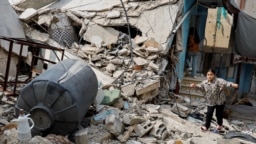 Palestinianos inspeccionam os danos, após um ataque israelita que durou vários dias, no campo de Jenin