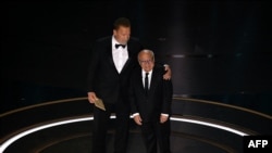 US actor Danny DeVito (R) and Austrian-US actor an former Governor of California Arnold Schwarzenegger present the award for Best Visual Effects onstage during the 96th Annual Academy Awards at the Dolby Theatre in Hollywood, California on March 10, 2024.