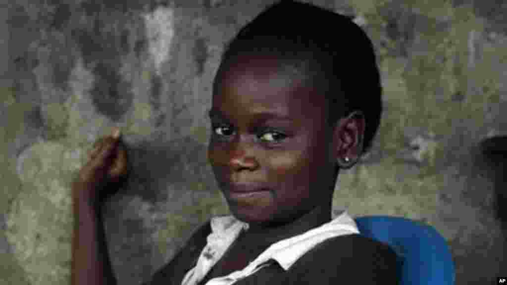 Kumba &laquo;survivante&raquo; Fayah, 11 ans, est assise avec des proches dans la maison familiale de St Paul Pont à Monrovia, au Libéria&nbsp; (photo prise le dimanche 28 septembre 2014). &nbsp;Fayah, qui a perdu ses deux parents et sa sœur, a elle-même été guérie d&rsquo;Ebola et vit maintenant avec sa famille élargie. 