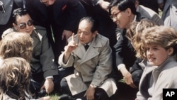历史照片：中国共产党领导人胡耀邦在英国莎士比亚的出生地同英国女学生坐在草地上交谈。(1986年6月10日)