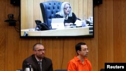 Defendant Larry Nassar (R) and his defense attorney Matt Newburg listen to Judge Janice Cunningham hand down his prison sentence during the sentencing hearing of Nassar, a former team USA Gymnastics, in the Eaton County Court in Charlotte, Michigan, Feb. 