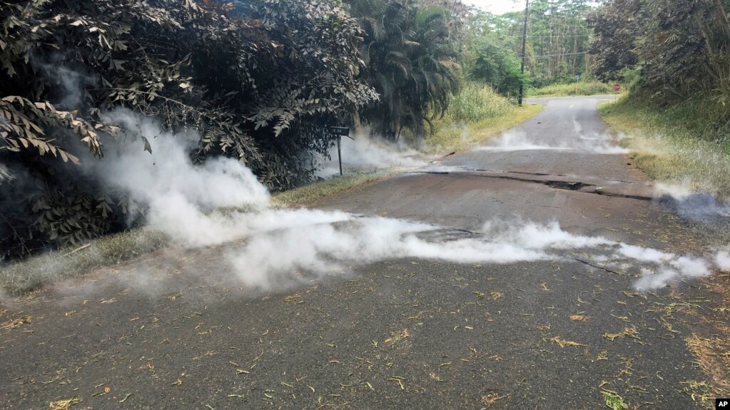 Fumes come out of cracks on the asphalt road near the Leilani Estates in Pahoa, Hawaii, May 5, 2018. 